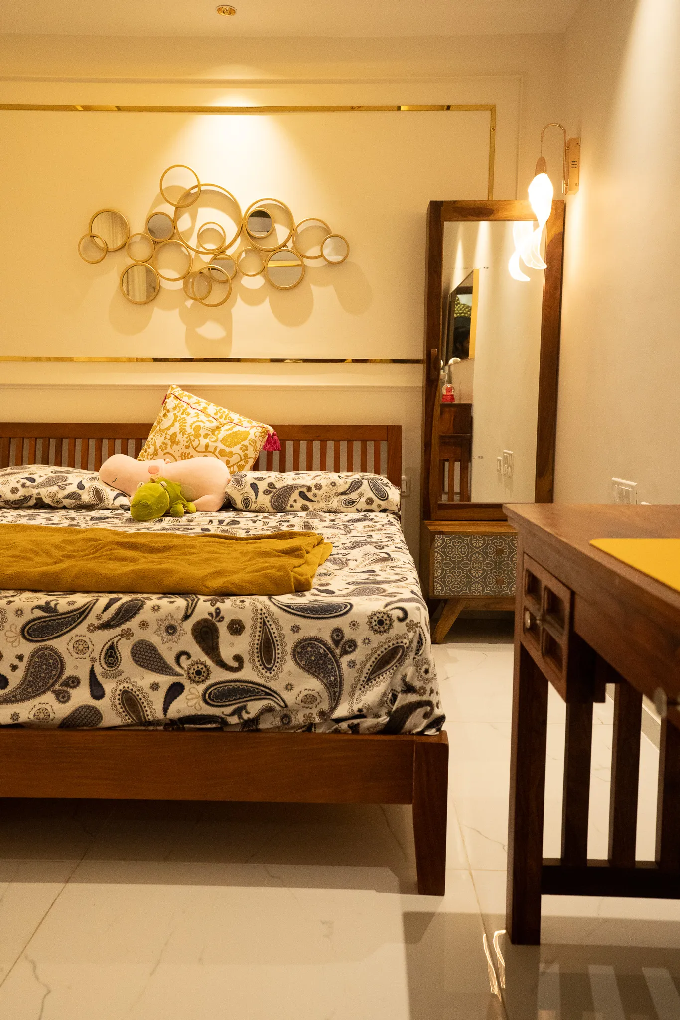 Bedroom with gold wall art and full-length mirror — Divyarjuna